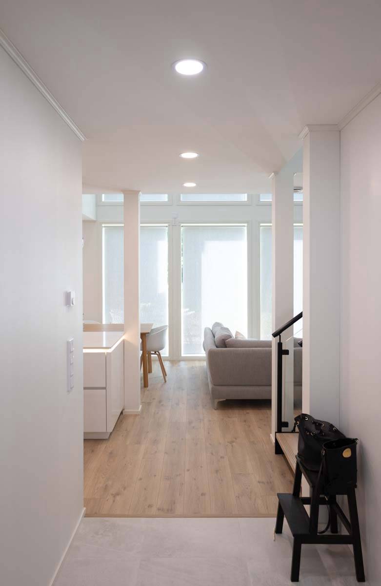 Le couloir s'ouvre sur le salon. Les luminaires Plafondi 160 prolongent l'éclairage de façon transparente entre les deux espaces. LedStore.fi